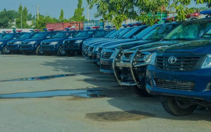 A line of marked police patrol vehicles at a Nigerian security formation